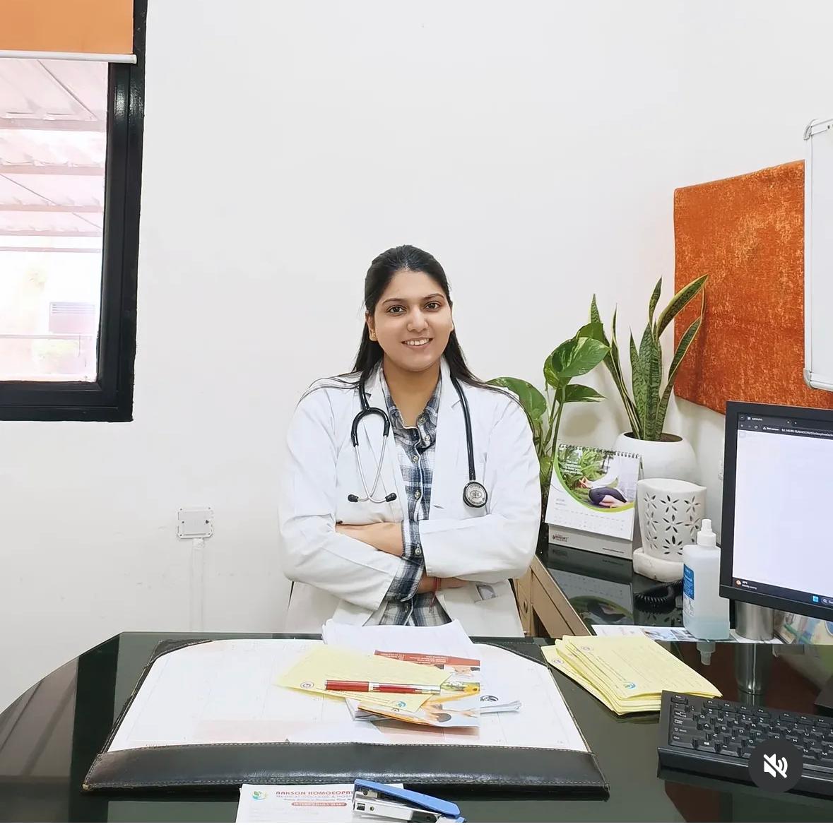 Dr. Nandini Agarwal seated in her clinic wearing a white coat and stethoscope